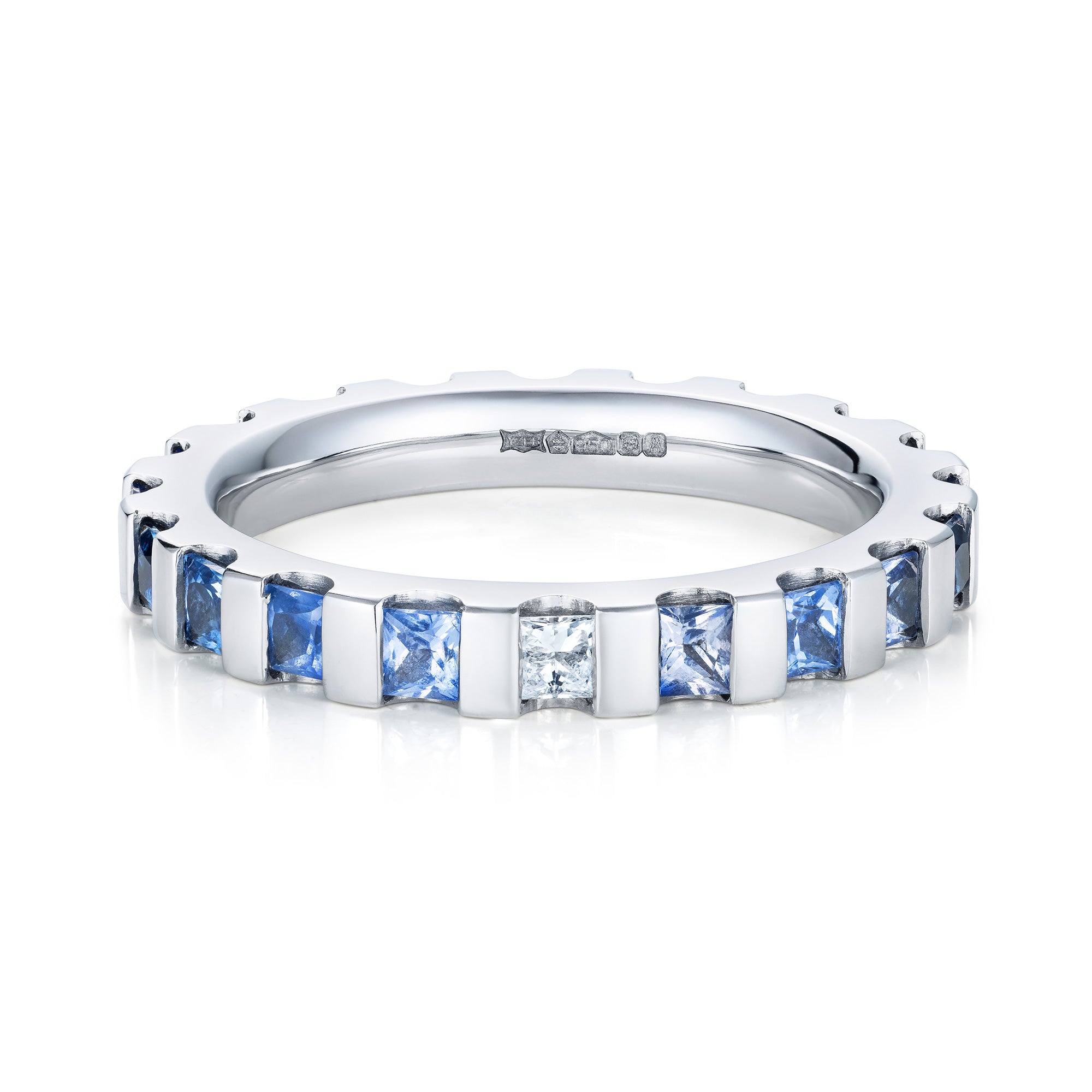 Platinum eternity ring white diamond in the centre, going out from light blue to deep blue sapphires. Front view.