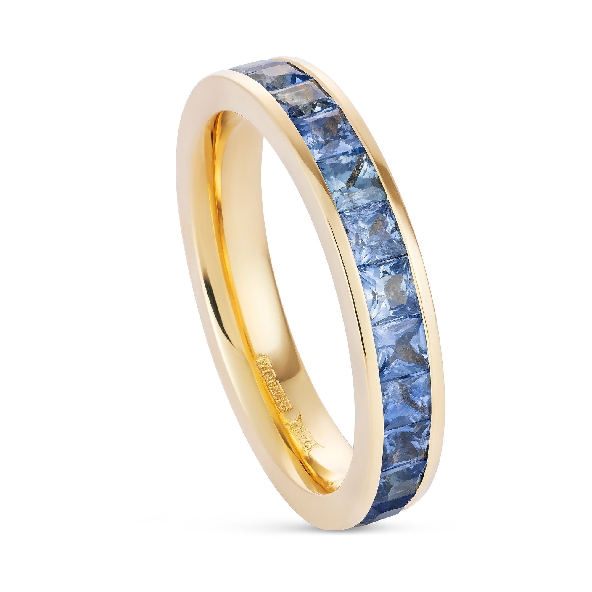 Ombré sapphire channel-set band in 18ct yellow gold by Yasmin Everley. Three quarter view.