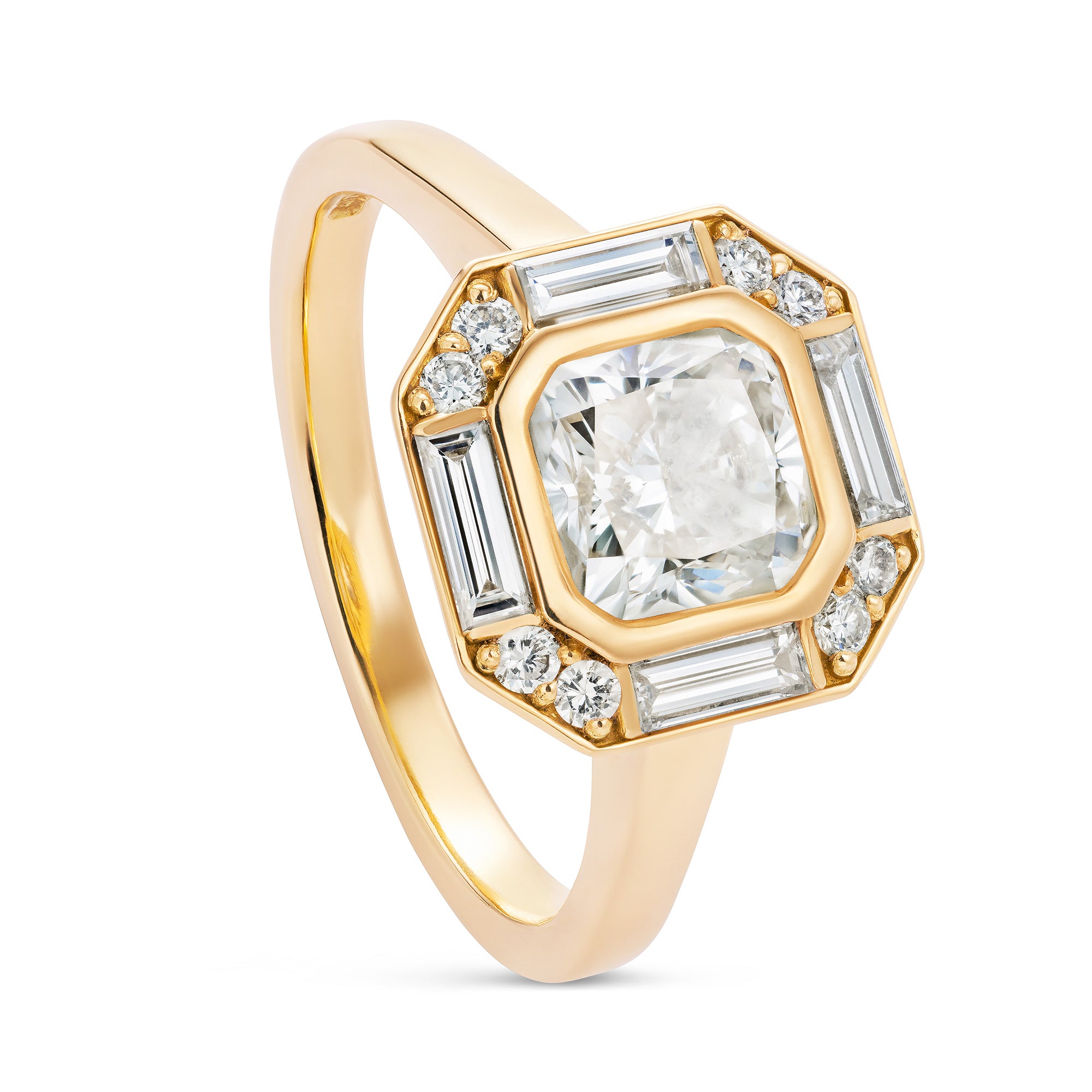 Yellow gold engagement ring with a warm cushion cut diamond in a halo of baguette and round diamonds. Designed by Yasmin Everley. Angled view.