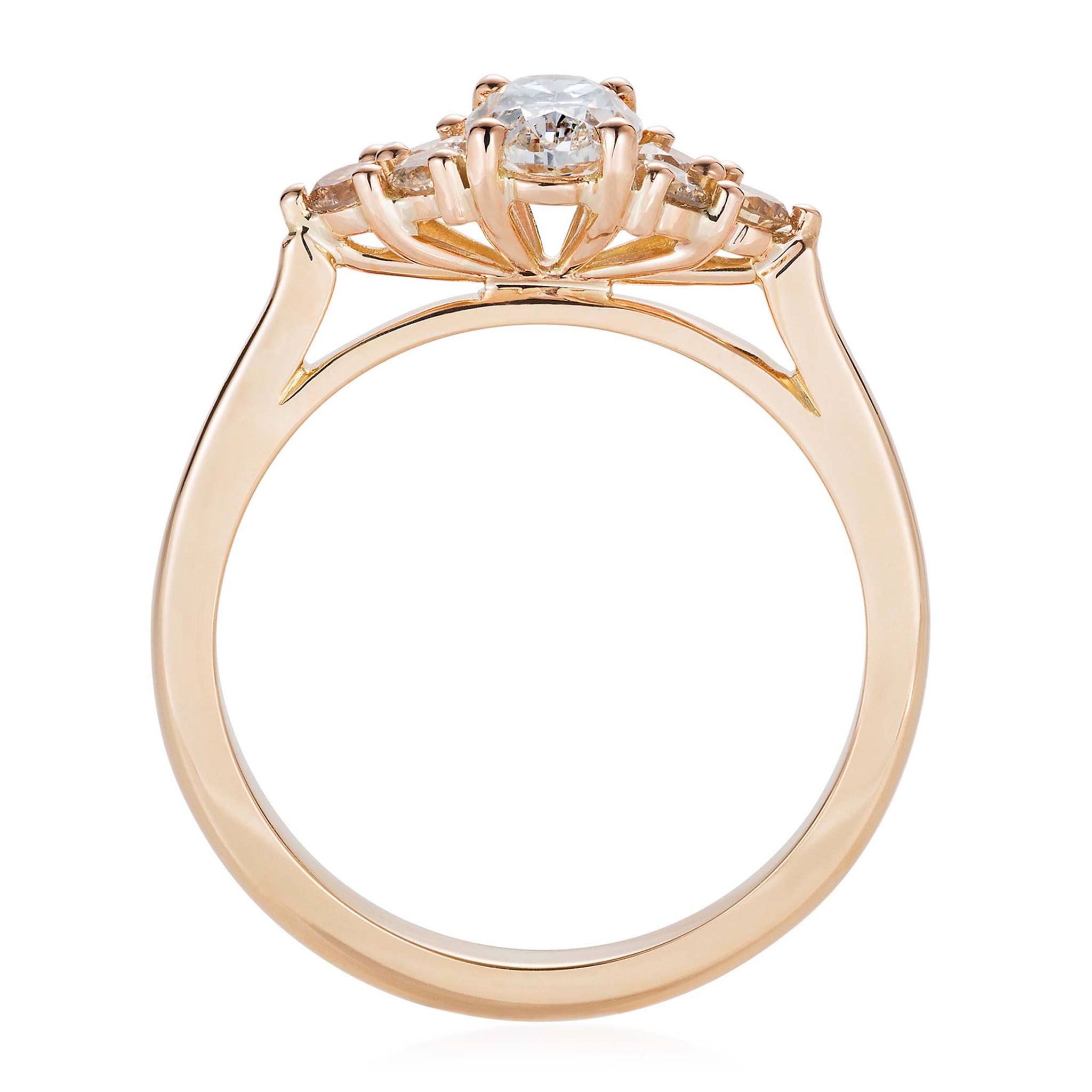 Yellow gold engagement ring with a white oval cut diamond accented by champagne and honey tone round diamonds. Designed by Yasmin Everley. Front view.